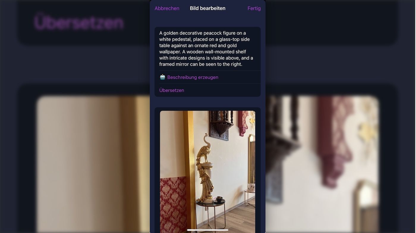 Screenshot of the ice cubes mastodon iPhone client on the „add alt text“ screen. Showing a photo and an AI generated alt text which exactly describes the image beneath: A golden decorative peacock figure on a white pedestal, placed on a glass-top side table against an ornate red and gold wallpaper. A wooden wall-mounted shelf with intricate designs is visible above, and a framed mirror can be seen to the right.